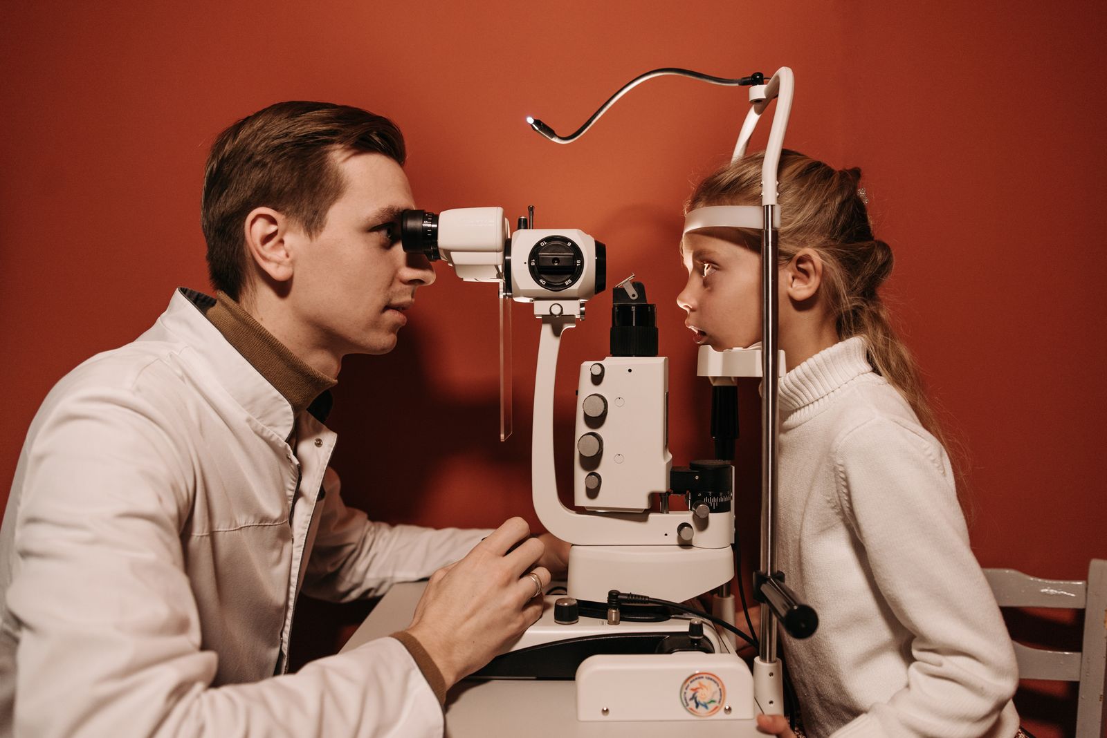 Ophthalmologist examining a child at a slit lamp